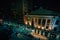 A view of buildings on Fayette Street at night, in downtown  Baltimore, Maryland