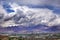 View of buildings in the new district of Lhasa, in Tibet, against the Himalaya Mountains covered by a dramatic sky.