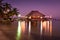 A view of the bungalow overwater beautifully lit up at dusk in Belize