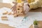 View of businessman in latex gloves near falling wooden blocks tower and papers with infographics