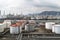 view of busy oil refinery, with huge storage tanks and pipes visible