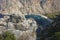 View of Butterfly Valley from Lycian Way hiking trail. Travel photo. Rocky cliff, yachts on blue sea surface, beach in deep canyon