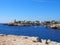 A view of Cala Santandria with lighthouse and boat in a bright summers day in Menorca Spain