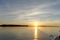 A view of the calm golden sunset on the river with the sun reflected in it, Volga, Russia