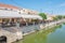 View of a canal in Lefkimi with houses and restaurants