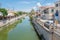 View of a canal in Lefkimi with houses and restaurants