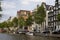 View of canal, parked boats, cars, trees