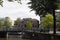 View of canal, people crossing a stone bridge