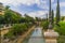 View of a canal of water crossing a park in the Historic Center of Palma de Mallorca, Spain