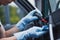 View of car cleaner dusting dashboard with rubber air blower