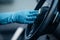 View of car cleaner in rubber glove wiping steering wheel