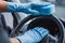 View of car cleaner in rubber gloves wiping steering wheel with sponge