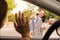 View from the car schoolgirl saying goodbye with the hand. Smiling latin girl waving goodbye to his mother before school