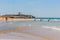View of Carcavelos Beach on a sunny autumn day with the Fortress of Sao Juliao da Barra in the background
