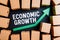 view Cardboard boxes with green chart arrow, economic growth concept