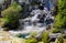 View on cascade with steaming hot clear blue alkali chloride thermal pool