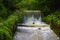 View of the cascade of water in the form of small waterfalls surrounded by trees. Selective focus