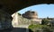 View of Castel Sant`Angelo from a bank of the Tiber river, framed by the shadow of a bridge