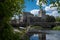 A view of the Castle of Cahir across the weir down the River Suir, bright blue sky and fluffy white clouds