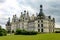 View of the Castle of Chambord in Centre-Val de Loire under a cloudy sky and green trees around it