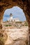 View from Cavalleria tunnel to the lighthouse Faro de Cavalleria. Menorca, Balearic islands, Spain vertical photo