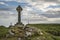 View of Celtic Cross on Angelsey with Twr Mawr Lighthouse in background landscape