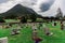 View on the cemetery by the medieval Stave Church in Lom and mountains against cloudy dramatic sky
