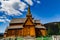 View on the cemetery, medieval Stave Church in Lom, mountains against cloudy sky on a sunny day