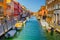 view of a channel on murano island in italy which is surrounded with tourist shops selling famous murano glass...IMAGE