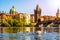 View on Charles bridge and Swans on Vltava river in Prague at sunset, Czech Republic