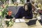 View of a cheerful young woman working as florist scheduling meeting on agenda in front of a small laptop, businesswoman concept