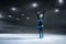 View of child  figure skater on dark ice arena