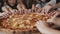 View of children`s fingers moving synchronously and fast to pizza in a centre