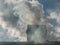 View of a chimney with white and grey dense smoke from burning firewood, pellets or briquettes