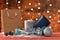 View of a Christmas decorations with a gift box and a paper bag on a table on an out of focus sparkling background. Christmas