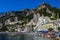 View of the city of Amalfi from the jetty with parked buses, the sea and the colorful houses on the slopes of the Amalfi coast in