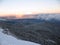 View of the city away from the mountain. Snow covered mountains with hills covered fir-tree forest. Winter mountains landscape