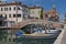 View of the city of Chioggia with wooden boats and bridge over canal, little Venice Italy