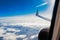 View of the city and clouds from the plane, the wing of the plane shooting through the window. travel