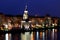 View of the city Dnepr, Ukraine, church with illuminating at autumn evening , lights reflected in the water.