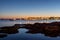 View of city lights and the sea in the foreground in the evening in  Porto Cesareo, Italy