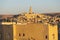 View of city with mud-brick dwelling and tall minaret against clear sky, Algeria, Ghardaia