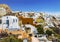 View of the city of Oia with white buildings, hotels, cafes and restaurants. Santorini,