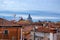 A view of classic older style rooftops across the Venice skyline with development in the distance