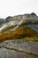 View from a cliff edge in the mountains of Lofoten Islands in Norway into a valley with a waterfall and lake