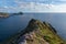 View from a cliff in Ireland with pink flowers in the foreground. View on the Skellig Islands