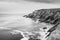 View of a cliff over a coastline with a beautiful misty sea from a view point on a beach in Mossel Bay, Cape Town