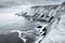 View of a cliff over a coastline with a beautiful misty sea from a view point on a beach in Mossel Bay, Cape Town