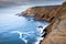 View of a cliff over a coastline with a beautiful misty sea from a view point on a beach in Mossel Bay, Cape Town