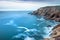 View of a cliff over a coastline with a beautiful misty sea from a view point on a beach in Mossel Bay, Cape Town